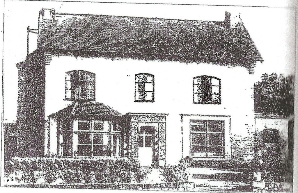 Black-and-white photograph of Armitage Cottage showing the two-storey house with three upper windows, a central doorway, a glazed bay window on the left and a garden in front.