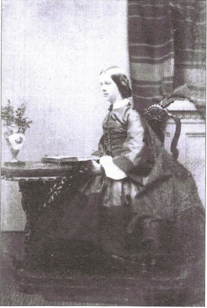 Victorian photograph of Susanna Sneyd seated beside a table, wearing a long dark dress, photographed by Josiah Spode IV in 1863.